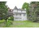 Two-story home with a tower and a charming covered front porch surrounded by mature trees and a green lawn at 7245 W Strickland St, Douglasville, GA 30134