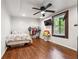 Bedroom with engineered wood flooring, clothing rack, and a mounted television at 1490 Ashbrook Dr, Lawrenceville, GA 30043