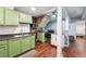 This kitchen features green cabinetry, stainless appliances, and wood-look floors at 1490 Ashbrook Dr, Lawrenceville, GA 30043