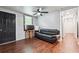 Living room featuring engineered wood flooring, black leather sofa, and modern decor at 1490 Ashbrook Dr, Lawrenceville, GA 30043