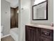 Bathroom with dark wood vanity, framed mirror, tile shower, and good lighting creating an inviting space at 1774 Northwick Pl, Lithonia, GA 30058