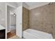 Bathroom featuring a shower, tile walls, and a view into the Primary bedroom at 1774 Northwick Pl, Lithonia, GA 30058