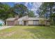 Traditional-style home featuring mature trees, a driveway, attached garage, and well-maintained lawn at 1774 Northwick Pl, Lithonia, GA 30058