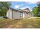 Yard view of tan-colored single story home with dark trim and dark roof at 1774 Northwick Pl, Lithonia, GA 30058