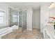 Stylish bathroom with a glass shower, a window, and soaking tub at 2865 Ferncliff St, Cumming, GA 30028