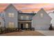 Inviting two-story home showcases white siding and a well-manicured front yard, captured at sunset at 2865 Ferncliff St, Cumming, GA 30028