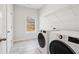 Well-lit laundry room with modern washer and dryer, plus storage shelves at 2865 Ferncliff St, Cumming, GA 30028