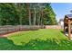 Large yard with a wooden fence, covered patio, green grass and an athletic net at 301 Downing Creek Trl, Canton, GA 30114