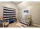 Adorable Bedroom with a crib, striped curtains, and stylish decor, creating a warm and inviting space for a baby at 301 Downing Creek Trl, Canton, GA 30114