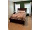 A bedroom with a queen sized bed, side table and two windows in the background at 301 Downing Creek Trl, Canton, GA 30114