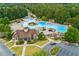Bird's eye view of the recreational waterpark-style community pool and clubhouse, framed by a dense forest at 301 Downing Creek Trl, Canton, GA 30114