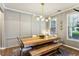 Elegant dining room featuring a wooden table with bench seating and modern lighting at 301 Downing Creek Trl, Canton, GA 30114