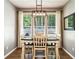 Light-filled dining room with white table, chairs, and modern light fixture at 301 Downing Creek Trl, Canton, GA 30114