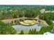An aerial view shows an island green on the golf course pond with nearby apartments and tall green trees around at 301 Downing Creek Trl, Canton, GA 30114