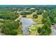Aerial view of golf course and pond surrounded by lush green trees within a residential neighborhood and roadways at 301 Downing Creek Trl, Canton, GA 30114