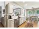 Kitchen featuring stainless steel appliances, white cabinets, marble countertops, and views to the living room and dining area at 301 Downing Creek Trl, Canton, GA 30114