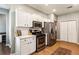 Modern kitchen with white cabinets, stainless steel appliances, and wood flooring at 301 Downing Creek Trl, Canton, GA 30114