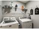 Functional laundry room with washer, dryer, shelving, and space-saving ironing board at 301 Downing Creek Trl, Canton, GA 30114
