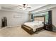 A serene primary bedroom with a king bed, tray ceiling, neutral tones, and lots of natural light to promote relaxation at 301 Downing Creek Trl, Canton, GA 30114