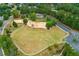 Community park aerial view showcases playground, sports courts, expansive green space, and lush trees for recreation at 301 Downing Creek Trl, Canton, GA 30114