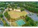 Aerial view of the community park featuring a playground, sports courts, open green space, and surrounding mature trees at 301 Downing Creek Trl, Canton, GA 30114