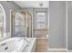 Large bathroom features soaking tub, a separate shower stall, and a large arched window at 4000 Crossings Way, Stone Mountain, GA 30083