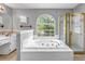 Bright bathroom features a soaking tub with tile surround and a separate shower stall at 4000 Crossings Way, Stone Mountain, GA 30083