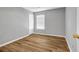 This bedroom features hardwood floors, a window with blinds, and neutral paint at 4000 Crossings Way, Stone Mountain, GA 30083