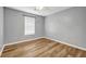 This bedroom features hardwood floors, a window with blinds, and neutral paint at 4000 Crossings Way, Stone Mountain, GA 30083