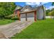 Well-maintained home with a driveway leading to an attached two-car garage and green lawn at 4000 Crossings Way, Stone Mountain, GA 30083
