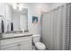 Neutral bathroom with gray granite countertops, gray and white striped shower curtain and chrome hardware at 647 East Ne Ave, Atlanta, GA 30312