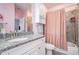 Traditional pink bathroom featuring granite countertops, white cabinets and chrome hardware at 647 East Ne Ave, Atlanta, GA 30312