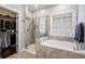 Stylish bathroom featuring a glass shower, soaking tub, and access to the walk-in closet at 647 East Ne Ave, Atlanta, GA 30312