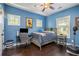 This blue bedroom features a wood bed frame, dark wood floors and a desk with chair at 647 East Ne Ave, Atlanta, GA 30312
