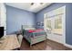 Bright bedroom with blue walls, hardwood floors, and access to outdoor balcony through glass doors at 647 East Ne Ave, Atlanta, GA 30312