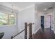 Upstairs hallway featuring wood floors, staircase, chandelier, and natural light from the window at 647 East Ne Ave, Atlanta, GA 30312