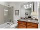 Well-lit bathroom featuring granite countertop, updated vanity, and tub-shower combo with glass enclosure at 1717 N Decatur Ne Rd # 214, Atlanta, GA 30307