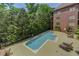 Outdoor swimming pool with trees, lounge chairs, tables, and tanning area at 1717 N Decatur Ne Rd # 214, Atlanta, GA 30307
