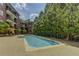 Outdoor swimming pool with trees, lounge chairs, tables, and tanning area at 1717 N Decatur Ne Rd # 214, Atlanta, GA 30307