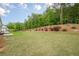 This large backyard features trees, landscaping, and lawn, creating a serene outdoor space at 2360 Charleston Manor Ln, Suwanee, GA 30024