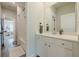 Bright bathroom showcasing a white vanity, large mirror, and shower/tub combo with tiled flooring at 2360 Charleston Manor Ln, Suwanee, GA 30024