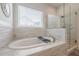 Elegant bathroom features a soaking tub, glass shower, and stylish tile flooring at 2360 Charleston Manor Ln, Suwanee, GA 30024