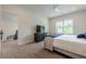 Bright bedroom with ceiling fan, neutral carpet, TV, and large window bringing in natural light at 2360 Charleston Manor Ln, Suwanee, GA 30024