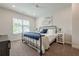 Sunlit bedroom with large window, iron bed frame, and stylish decor at 2360 Charleston Manor Ln, Suwanee, GA 30024