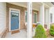 Inviting front porch with rocking chairs, a brick facade, and a blue front door at 2360 Charleston Manor Ln, Suwanee, GA 30024