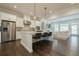 Open-concept kitchen with island seating, stainless steel appliances, and seamless flow to living area at 2360 Charleston Manor Ln, Suwanee, GA 30024