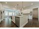 Kitchen island with seating, modern appliances, and open view into the living room at 2360 Charleston Manor Ln, Suwanee, GA 30024