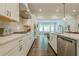 Bright kitchen with white cabinets, stainless appliances, quartz countertops, and hardwood floors at 2360 Charleston Manor Ln, Suwanee, GA 30024