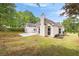 View of the house from the backyard featuring a concrete patio and mature trees at 3187 Gainer Dr, Powder Springs, GA 30127