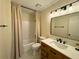 Well-lit bathroom featuring shower-tub, neutral paint, matching cabinets, tile flooring and modern fixtures at 3340 Zingara Rd, Conyers, GA 30012